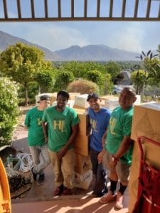 Heavy Lift Moving Co. movers loading boxes on a residential move in Utah with mountain views in the background.